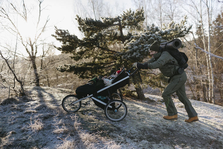 Mann med barnevogn i frostdekket natur