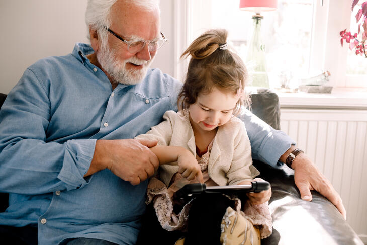 Bestefar med barnebarn på fanget ser på et nettbrett